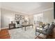 Inviting living room with hardwood floors, a neutral color palette, and an open view into the dining room at 9470 Dominion Way, Alpharetta, GA 30022