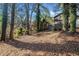 Leaf covered backyard with mature trees behind a house with a deck on the side at 2814 Lloyd Rd, Decatur, GA 30034