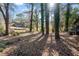 Leaf covered backyard with mature trees in the rear and a deck behind the house at 2814 Lloyd Rd, Decatur, GA 30034