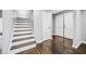 Hallway featuring hardwood floors, a staircase, and white doors, providing a clean and bright transition space at 2814 Lloyd Rd, Decatur, GA 30034