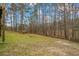 View of the sprawling backyard with its mature trees, fire pit, and natural landscape at 3773 Galdway Dr, Snellville, GA 30039