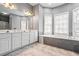 Large bathroom with dual sinks, soaking tub, and natural light at 3773 Galdway Dr, Snellville, GA 30039