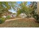 Expansive backyard featuring a lush green lawn, mature trees, and a wooden fence providing privacy and charm at 4710 Vineyard Se Ct, Smyrna, GA 30082
