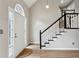 Bright entryway featuring a white door and staircase with black and white banister at 4710 Vineyard Se Ct, Smyrna, GA 30082