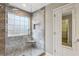 This tiled walk-in shower features a window, a built-in bench and conveniently located adjacent to the closet at 4710 Vineyard Se Ct, Smyrna, GA 30082