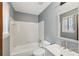 Bathroom with tiled tub and shower, vanity, and window at 1057 Forest Path, Stone Mountain, GA 30088