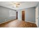 Bedroom features wood-look flooring, ceiling fan, window, and neutral walls at 1057 Forest Path, Stone Mountain, GA 30088