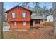 Cozy two-story home with red siding, complementary brown shutters, and a charming stone-accented front porch at 1057 Forest Path, Stone Mountain, GA 30088