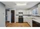 Kitchen with white cabinets, black appliances, and wood-look flooring at 1057 Forest Path, Stone Mountain, GA 30088