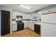 Kitchen with white cabinets, black appliances, and wood-look flooring at 1057 Forest Path, Stone Mountain, GA 30088