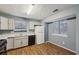 Kitchen with white cabinets, black appliances, and wood-look flooring at 1057 Forest Path, Stone Mountain, GA 30088