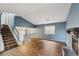 Spacious living room with fireplace, wood-look flooring, stairs, and upstairs landing at 1057 Forest Path, Stone Mountain, GA 30088
