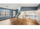 Open-concept living room with wood-look flooring, stairs, and lots of natural light at 1057 Forest Path, Stone Mountain, GA 30088