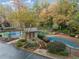 Aerial view of tennis courts, pool and gardens in a residential condo community with mature trees and landscaping at 801 Cumberland Se Ct, Smyrna, GA 30080