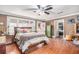 Cozy bedroom features wood floors, ceiling fan, and a colorful door leading to outdoor space at 204 Emory St, Oxford, GA 30054