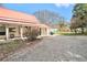 Outdoor space with gravel, red roof home, covered porch, and ample parking for convenience at 204 Emory St, Oxford, GA 30054