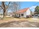 Quaint cottage-style home featuring a red roof, inviting front porch, and a spacious yard at 204 Emory St, Oxford, GA 30054