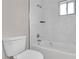 Clean, tiled bathroom with a toilet, showerhead, and tub with updated fixtures at 3236 Abbeywood Dr, Decatur, GA 30034
