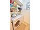 A neat laundry room with side by side washer and dryer and open shelving at 3777 Peachtree Ne Rd # 733, Atlanta, GA 30319