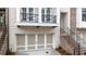 Townhome featuring a front-entry garage, balcony, and brick stairway with iron railings at 275 Briscoe Way # 3, Alpharetta, GA 30009