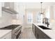 Spacious kitchen featuring a large island with sink, white cabinets, stainless steel appliances, and modern lighting at 275 Briscoe Way # 3, Alpharetta, GA 30009