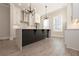 Bright kitchen with modern light fixtures, white cabinetry, and large island with breakfast bar at 275 Briscoe Way # 3, Alpharetta, GA 30009