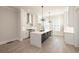 Bright kitchen features a large waterfall island, stainless steel appliances and modern pendant lighting at 275 Briscoe Way # 3, Alpharetta, GA 30009