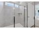 Modern bathroom featuring a glass-enclosed shower with gray tiling and a small window for natural light at 701 Bickmore Dr, Mcdonough, GA 30253