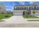 Inviting townhome featuring gray siding, brick accents, a two-car garage, and a well-manicured lawn at 701 Bickmore Dr, Mcdonough, GA 30253