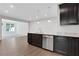 Contemporary kitchen featuring dark cabinets, granite countertops, stainless steel appliances, and light wood flooring at 701 Bickmore Dr, Mcdonough, GA 30253