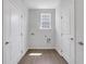 Bright laundry room features white walls, wood-look floors, and a window for natural light at 701 Bickmore Dr, Mcdonough, GA 30253
