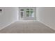 Bright living room featuring plush carpeting, neutral walls, and a glass door leading to outdoor space at 701 Bickmore Dr, Mcdonough, GA 30253