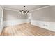 Bright dining room featuring modern light fixture, beautiful wood floors, and decorative wall trim at 743 Cedar Sw Trce, Lilburn, GA 30047