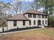 Two-story home with light-colored brick, brown shutters, manicured landscaping, and a welcoming front entrance at 743 Cedar Sw Trce, Lilburn, GA 30047