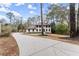 View of a two-story home with light-colored brick, brown shutters, manicured landscaping and a long driveway at 743 Cedar Sw Trce, Lilburn, GA 30047