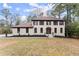 Two-story home with light-colored brick, brown shutters, manicured landscaping, and a welcoming front entrance at 743 Cedar Sw Trce, Lilburn, GA 30047