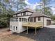 Back of home with elevated deck and sunroom, surrounded by greenery at 743 Cedar Sw Trce, Lilburn, GA 30047