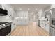 Modern kitchen featuring stainless steel appliances, white cabinets, light countertops, and wooden floors at 743 Cedar Sw Trce, Lilburn, GA 30047