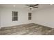 Bright bedroom featuring new floors, a ceiling fan, and two large windows at 6350 Akins Way, Cumming, GA 30041