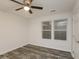 Cozy bedroom featuring a ceiling fan, two windows, modern flooring and closet door at 6350 Akins Way, Cumming, GA 30041