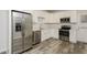 Modern kitchen featuring stainless steel appliances, white cabinets, and new floors at 6350 Akins Way, Cumming, GA 30041
