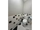 Clean bathroom featuring a toilet with black and white tile and neutral gray walls at 7248 Mountain Laurel Way, Stockbridge, GA 30281