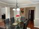 Elegant dining room with stylish chandelier, a glass-topped table, and black leather chairs at 7248 Mountain Laurel Way, Stockbridge, GA 30281