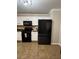 Well-equipped kitchen with white cabinets, black appliances, and tiled flooring at 7248 Mountain Laurel Way, Stockbridge, GA 30281