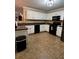 Well-lit kitchen with white cabinetry, black appliances, and neutral tile flooring at 7248 Mountain Laurel Way, Stockbridge, GA 30281