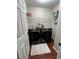 Modern laundry room with dual black front load washers and wooden laminate flooring at 7248 Mountain Laurel Way, Stockbridge, GA 30281
