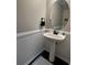 Powder room with an oval mirror and updated pedestal sink at 7248 Mountain Laurel Way, Stockbridge, GA 30281