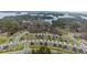 Aerial view of a residential area with modern homes, green lawns, and beautiful lake in the background at 6451 Crest Brook Way, Buford, GA 30518