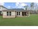 Expansive backyard features a covered patio, lush green grass, and ample space for outdoor enjoyment at 6451 Crest Brook Way, Buford, GA 30518