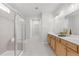 Bright bathroom featuring a double vanity, large mirror, and a glass-enclosed shower at 6451 Crest Brook Way, Buford, GA 30518